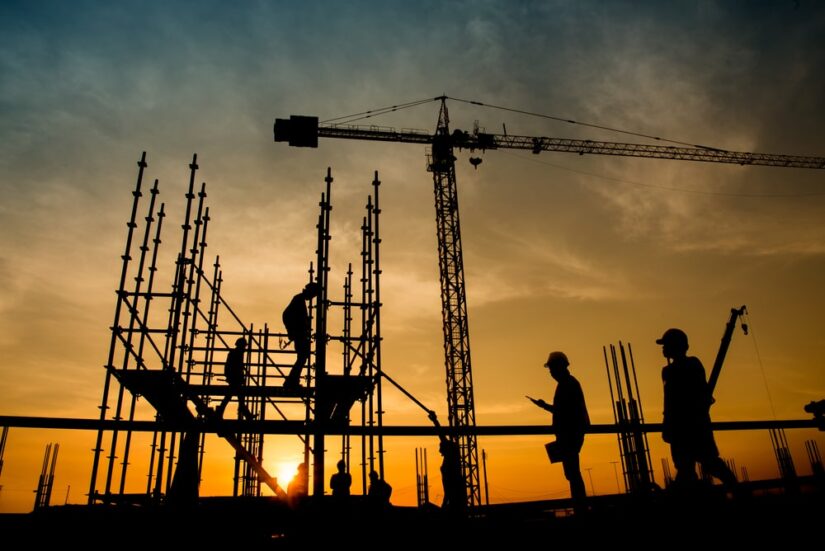 Construction Workers Building Scaffolding In Sunset