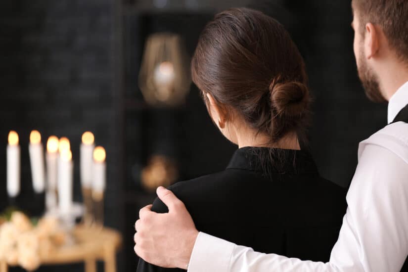 Couple pining after their relative at funeral
